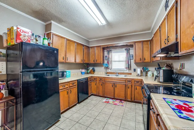 a kitchen with stainless steel appliances granite countertop a stove top oven a sink dishwasher and cabinets with wooden floor