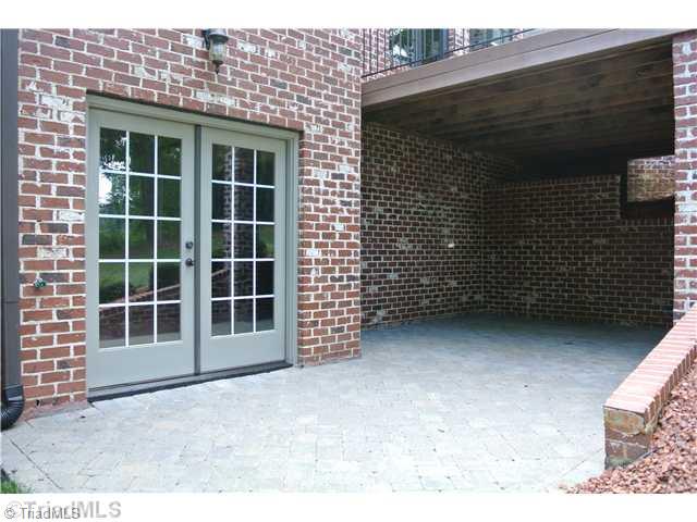 8522 Rosedale Drive Oak Ridge, NC 27310 - Photo 5 of 16 Exterior Back. Lower Level patio with brick pavers. French doors leading from partially finished basement.