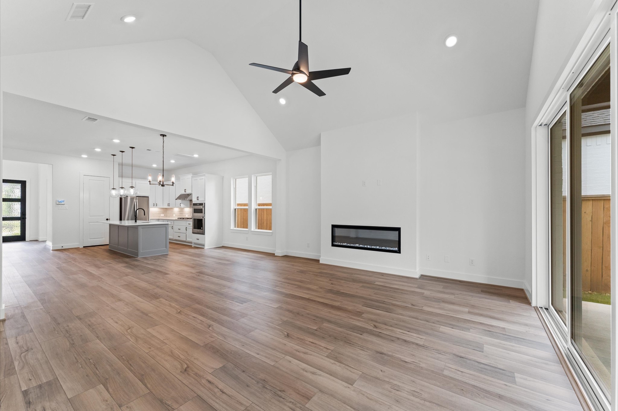 8218 Sherman Pk Trail Spring, TX 77389 - Photo 6 of 28 a view of a kitchen with a kitchen island wooden floor and a ceiling fan
