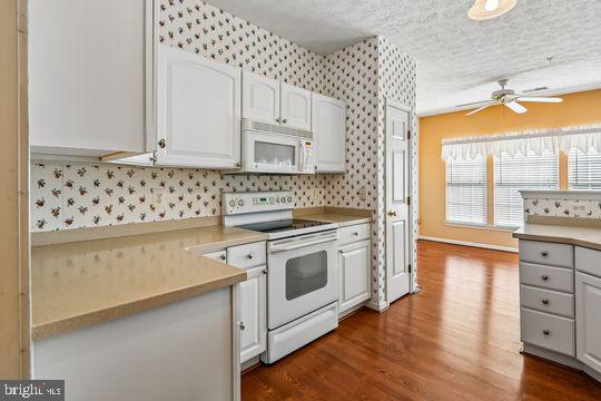 9511 Kingscroft Terrace, Unit 9511F Perry Hall, MD 21128 - Photo 22 of 38 a kitchen with granite countertop white cabinets and white appliances