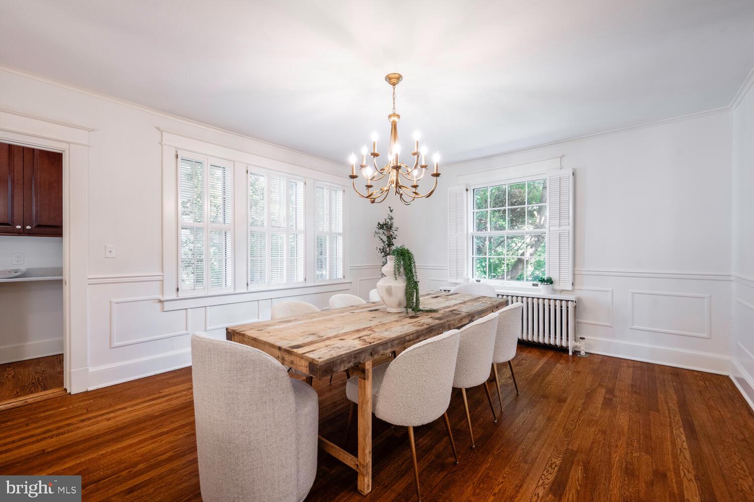5804 Cedar Parkway Chevy Chase, MD 20815 - Photo 12 of 95 a dining room with wooden floor a chandelier a wooden table and chairs