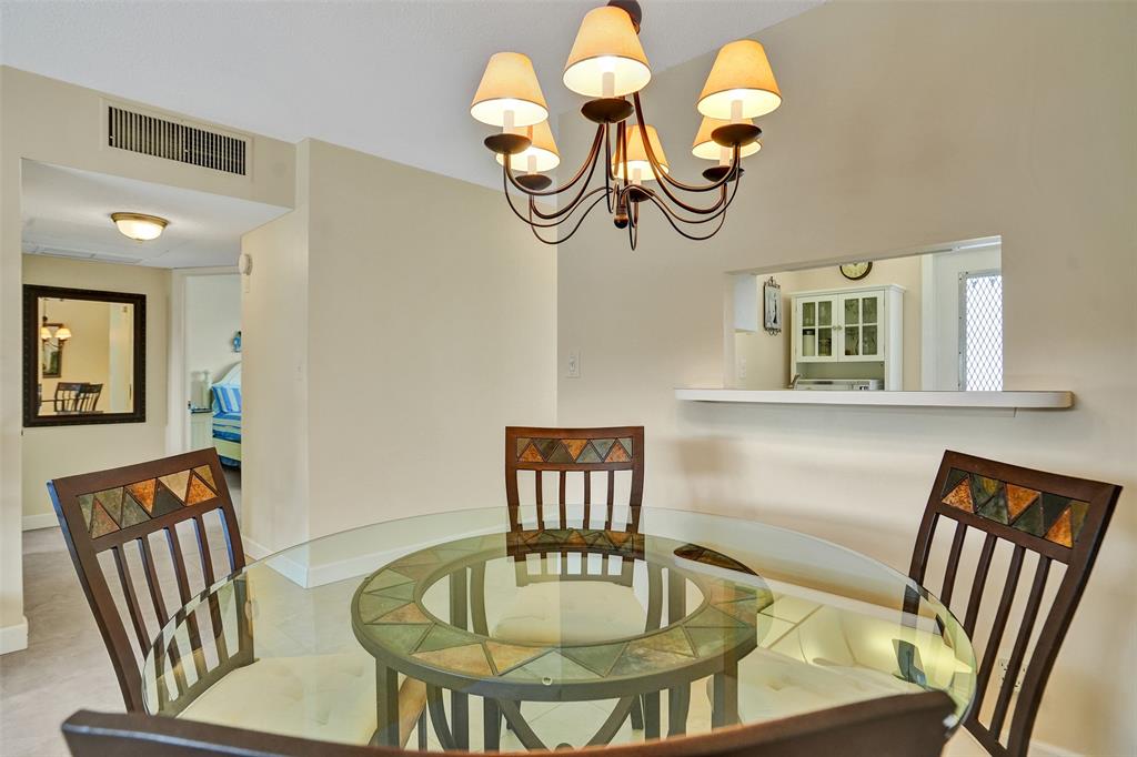 4431 Northwest 16th Street, Unit 209 Lauderhill, FL 33313 - Photo 3 of 27 a view of a dining room with furniture wooden floor and a chandelier