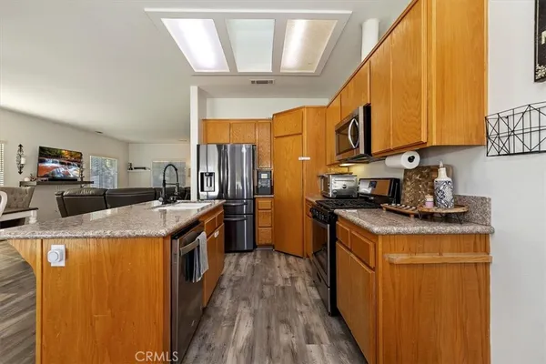 a kitchen with stainless steel appliances granite countertop a stove a sink and a refrigerator