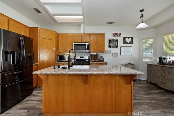 a kitchen with kitchen island a counter top space appliances and a window