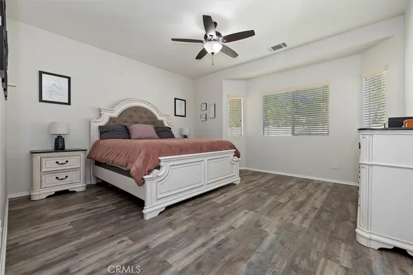 a bed room with a bed and a ceiling fan