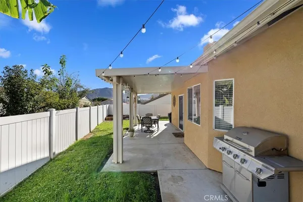 a patio with couches table and chairs and potted plants