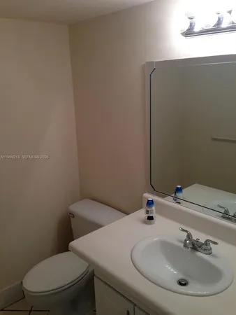 a white toilet sitting next to a bathroom sink