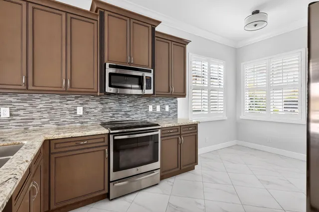 a kitchen with granite countertop a stove top oven microwave and cabinets