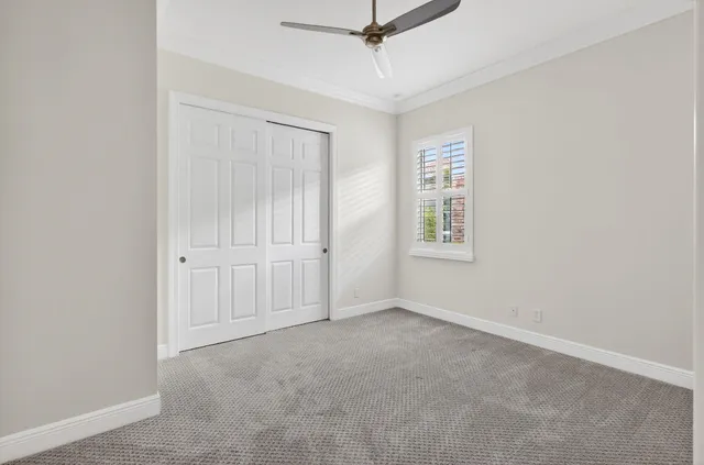 an empty room with windows and fan