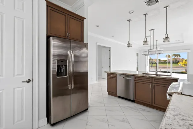 a kitchen with stainless steel appliances granite countertop a refrigerator and a sink