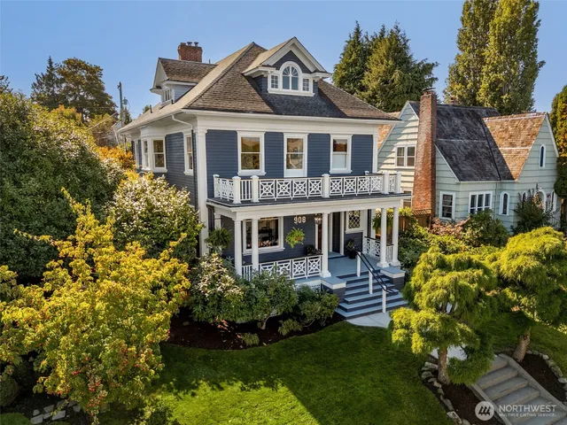 a front view of a house with a yard and potted plants