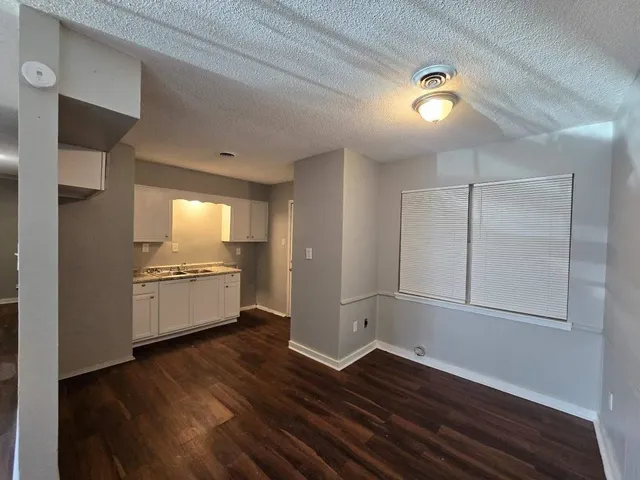 an empty room with wooden floor and window
