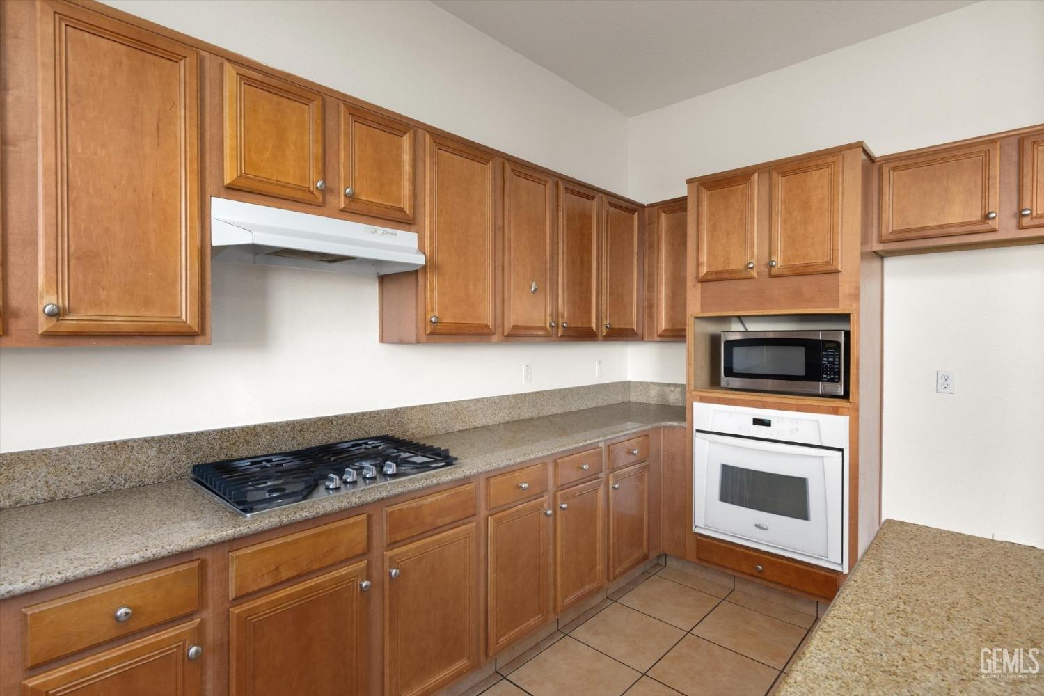 Undisclosed Address Bakersfield, CA 93313 - Photo 16 of 34 a kitchen with granite countertop cabinets and steel stainless steel appliances
