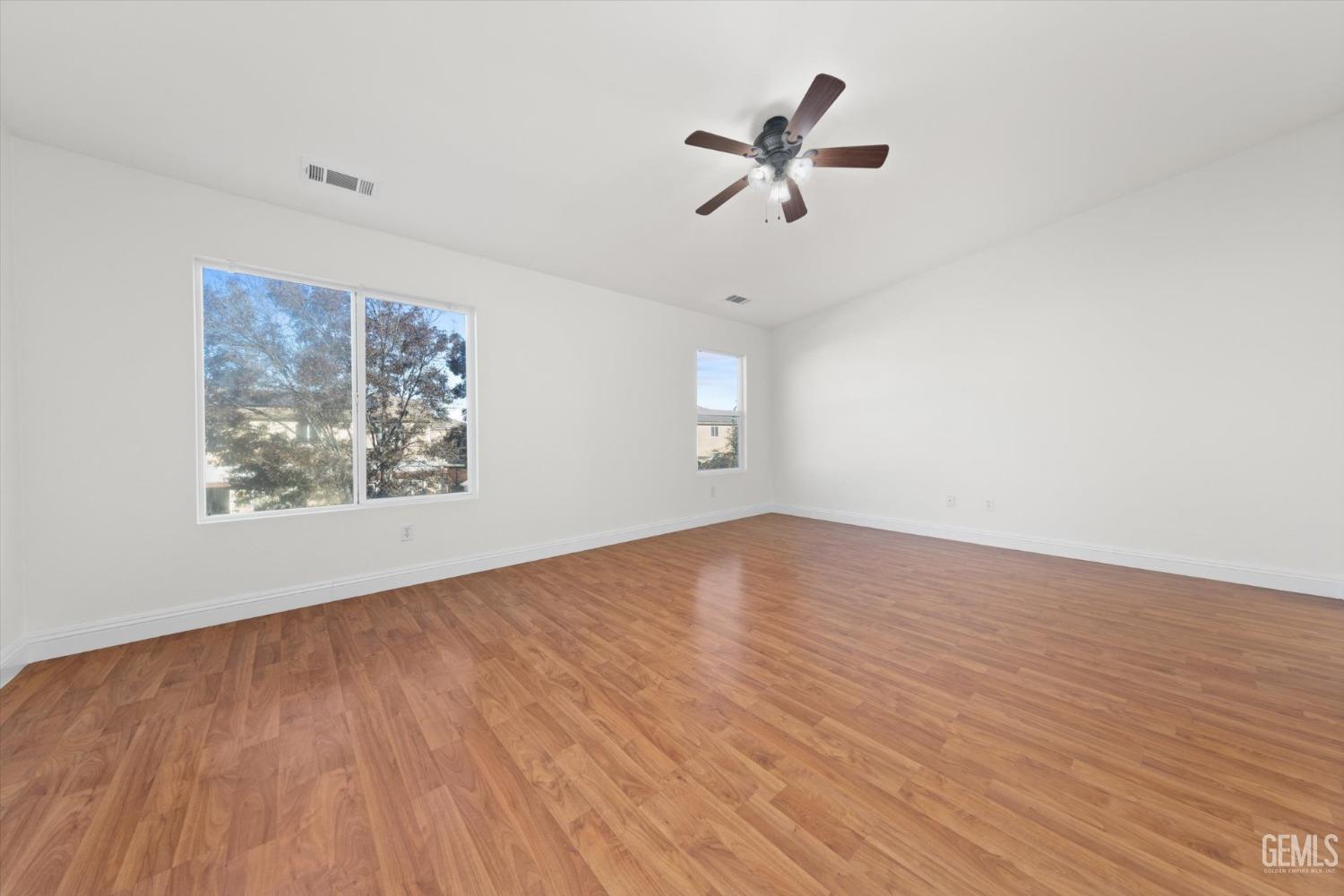 Undisclosed Address Bakersfield, CA 93313 - Photo 19 of 34 a view of empty room with wooden floor and fan
