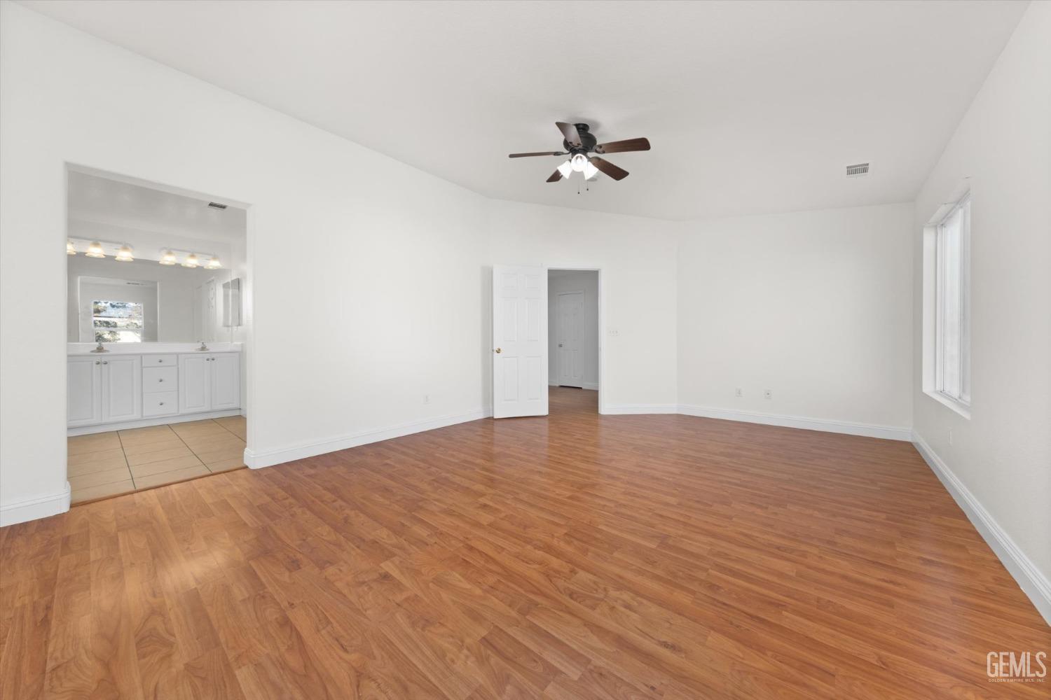 Undisclosed Address Bakersfield, CA 93313 - Photo 20 of 34 a view of empty room with wooden floor and ceiling fan