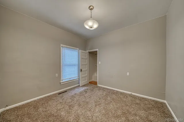 an empty room with windows and cabinet