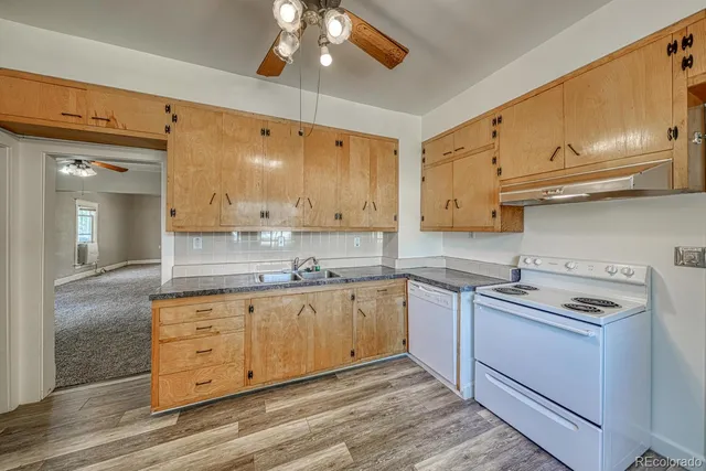 a kitchen with stainless steel appliances granite countertop a sink a stove and cabinets