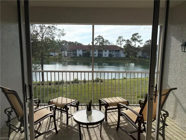 a view of a chairs and table in patio with a lake view