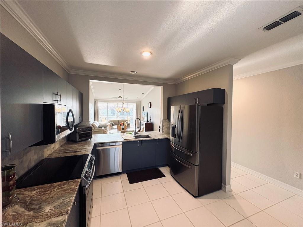 685 Luisa Lane, Unit 4 Naples, FL 34104 - Photo 14 of 25 a kitchen with a refrigerator and a stove top oven