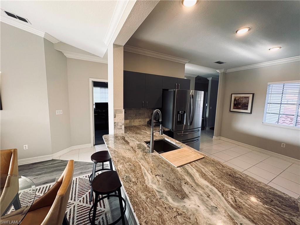 685 Luisa Lane, Unit 4 Naples, FL 34104 - Photo 15 of 25 a bed room with a bed and a chair