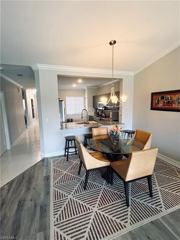685 Luisa Lane, Unit 4 Naples, FL 34104 - Photo 18 of 25 a dining room with furniture a rug and wooden floor