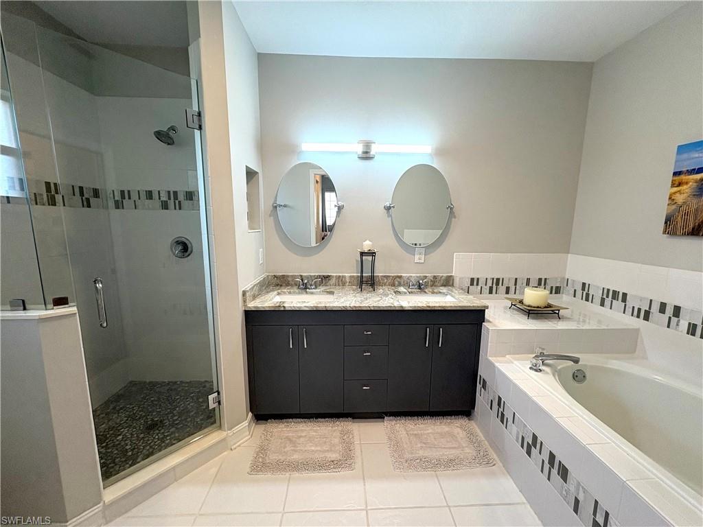 685 Luisa Lane, Unit 4 Naples, FL 34104 - Photo 7 of 25 a bathroom with a tub a sink and a mirror