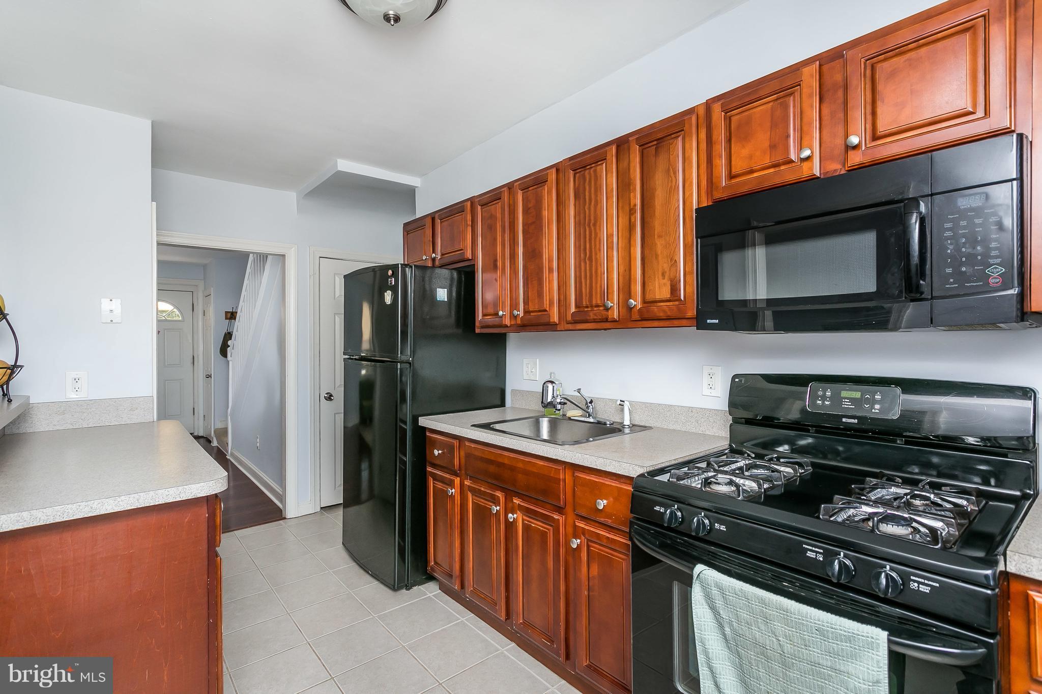 902 Andover Road Baltimore, MD 21218 - Photo 9 of 30 a kitchen with stainless steel appliances granite countertop a stove microwave refrigerator and sink