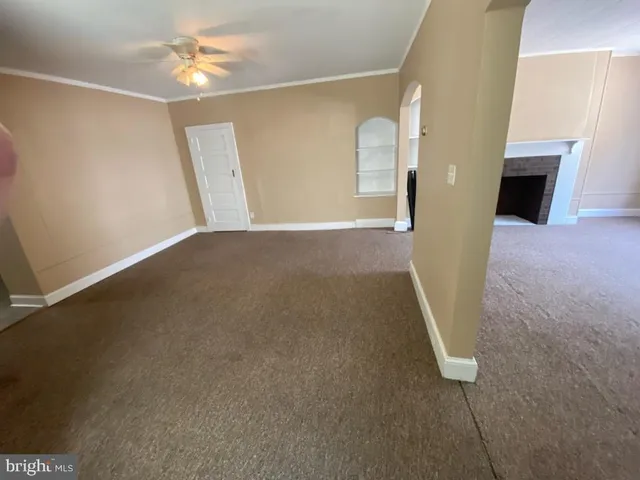 en empty room with windows and fireplace