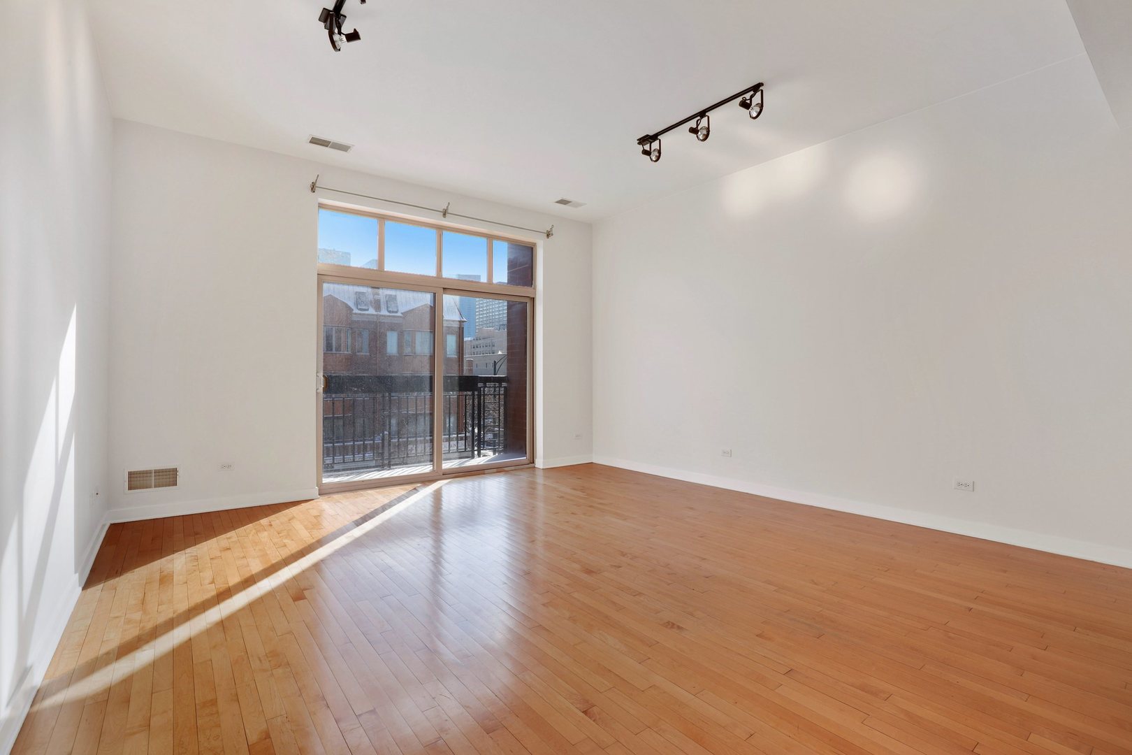 1910 South State Street, Unit 303 Chicago, IL 60616 - Photo 3 of 19 a view of an empty room with wooden floor and a window