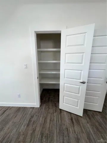 a view of walk in closet with empty racks