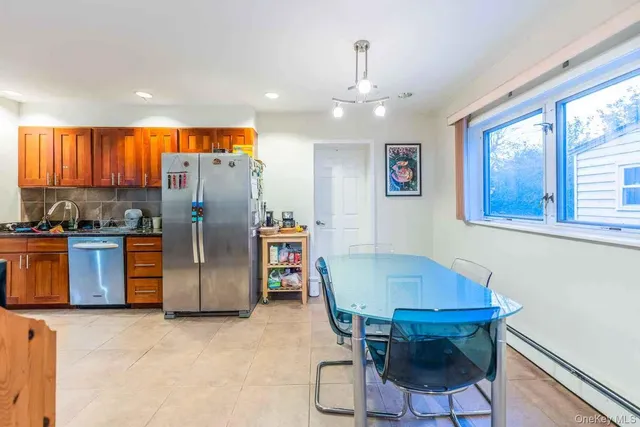a view of kitchen with stainless steel appliances granite countertop dining table and chairs