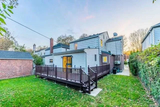 a view of a house with wooden deck and furniture