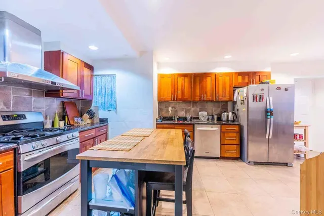 a kitchen with stainless steel appliances granite countertop a sink a stove and a refrigerator