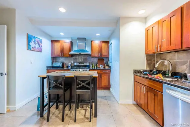 a kitchen with stainless steel appliances granite countertop a stove a sink a refrigerator and a refrigerator