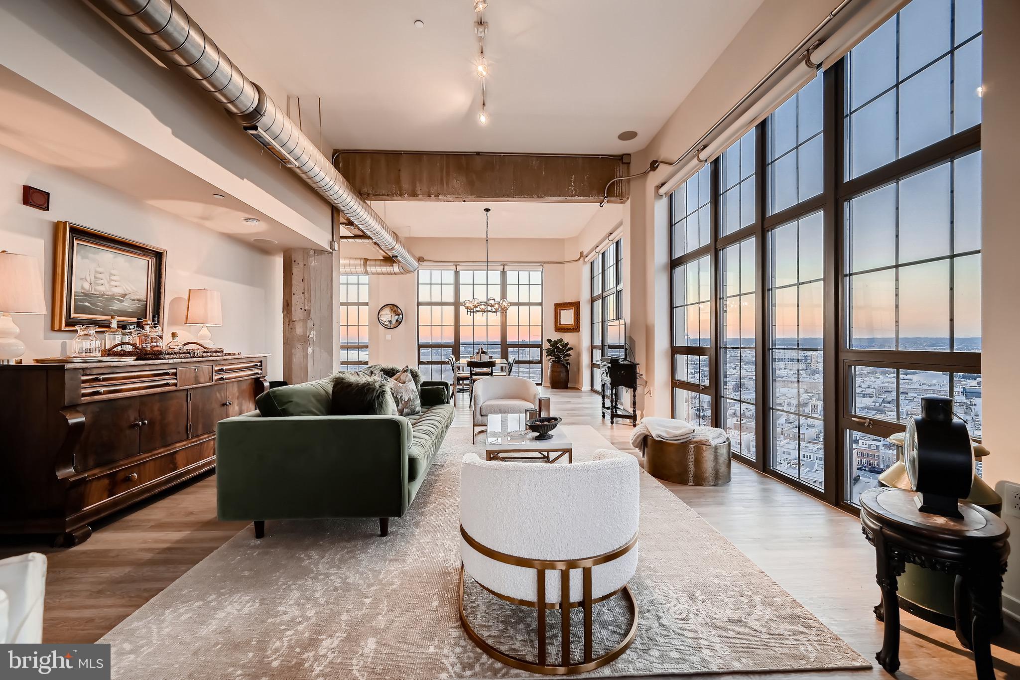 a living room with furniture a large window and kitchen view
