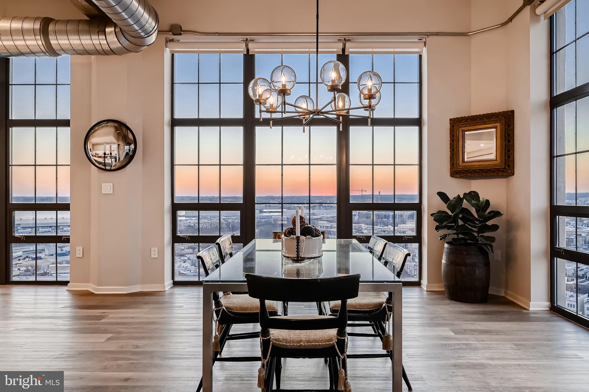 1200 Steuart Street, Unit 1611 Baltimore, MD 21230 - Photo 12 of 34 a view of a dining room with furniture a chandelier and wooden floor