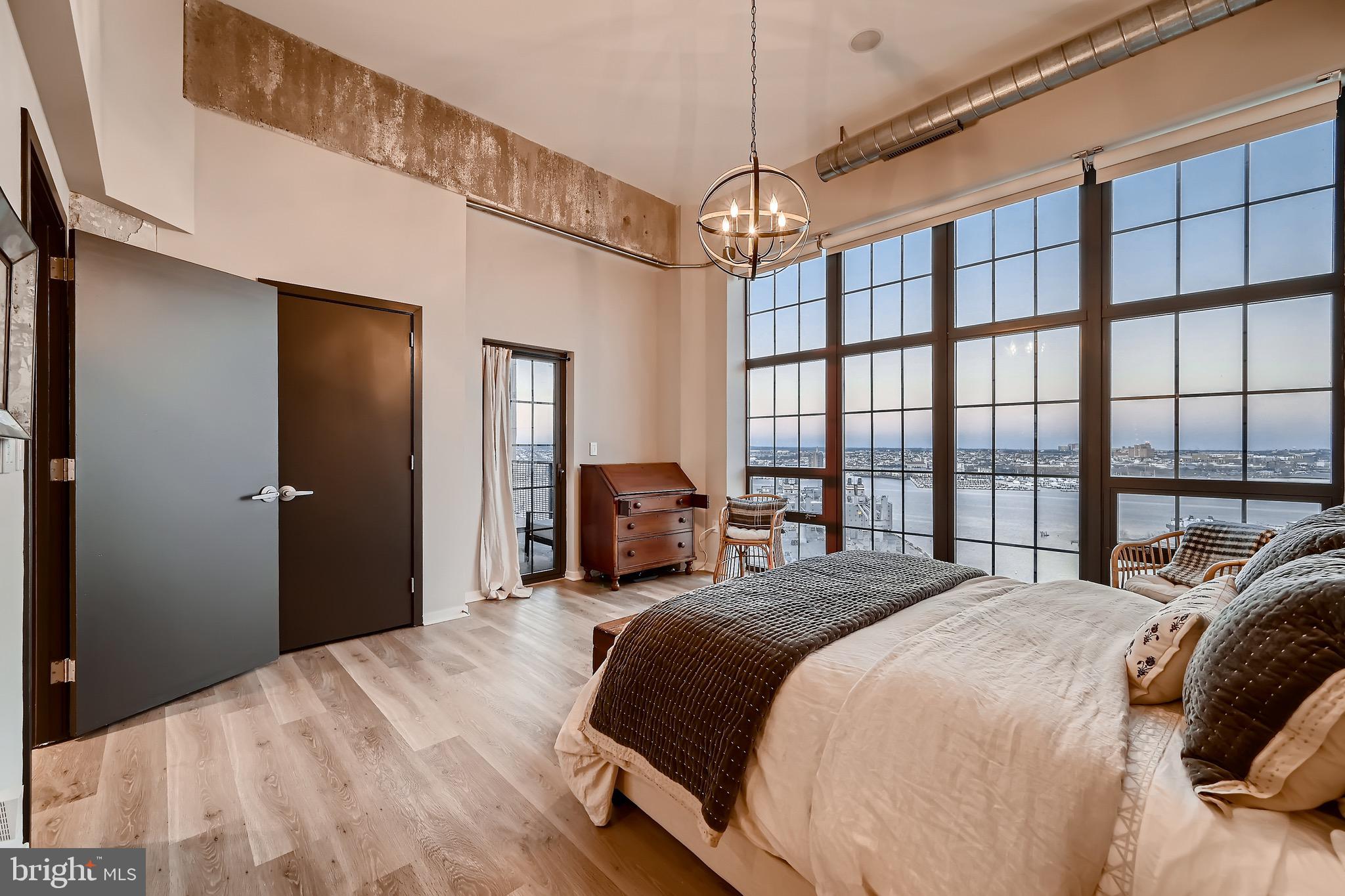 1200 Steuart Street, Unit 1611 Baltimore, MD 21230 - Photo 21 of 34 a bedroom with a large bed and a chandelier