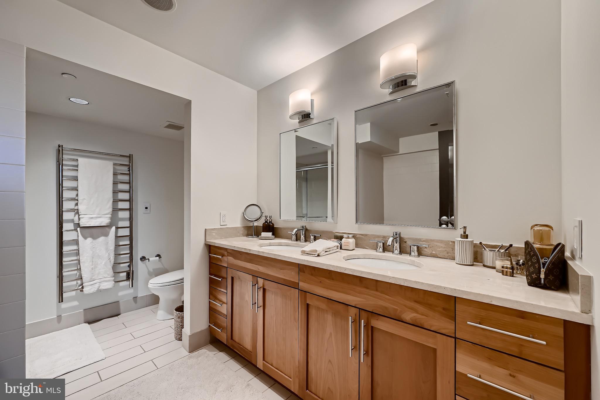 1200 Steuart Street, Unit 1611 Baltimore, MD 21230 - Photo 23 of 34 a spacious bathroom with a double vanity sink toilet and shower