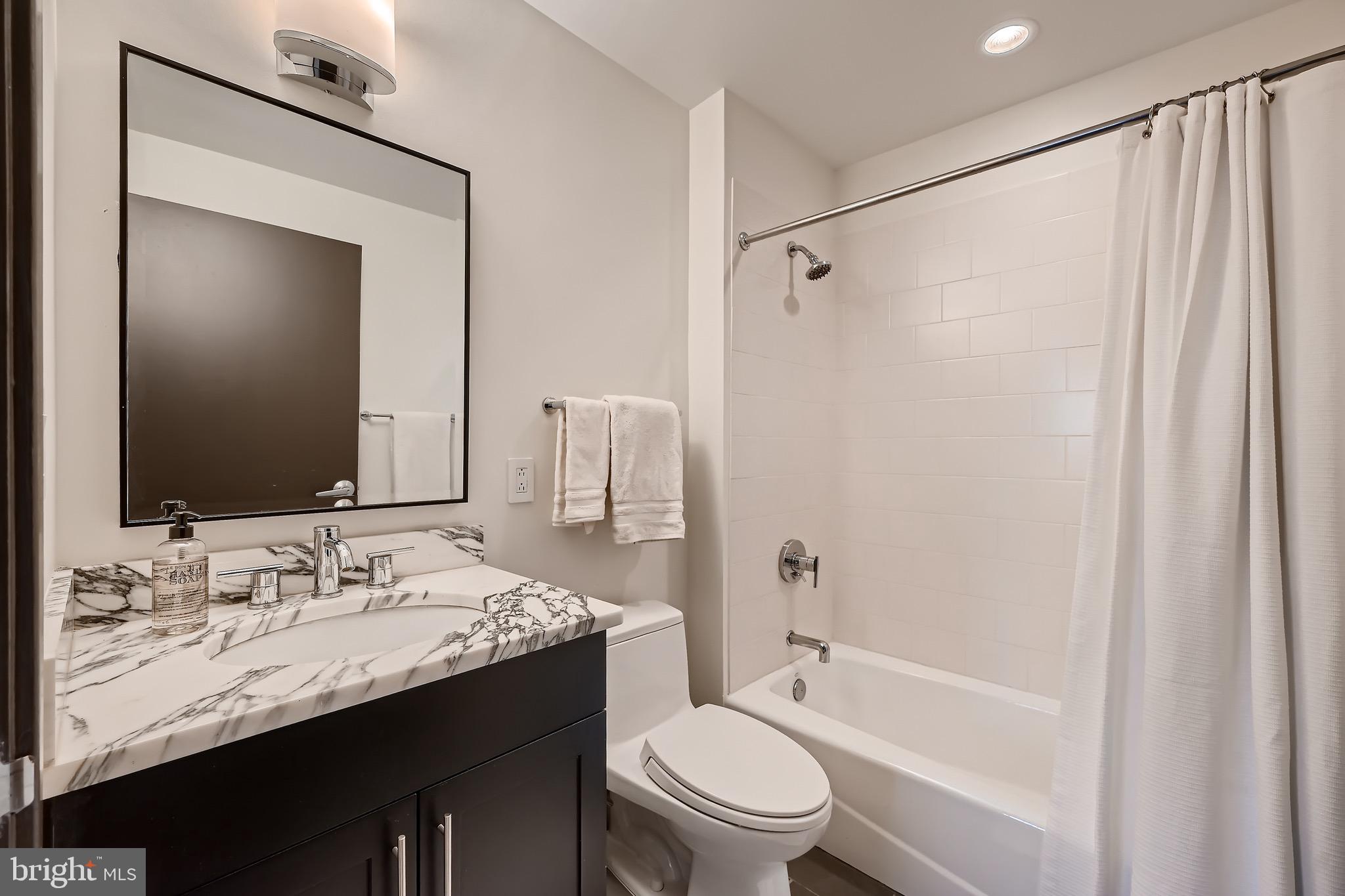 1200 Steuart Street, Unit 1611 Baltimore, MD 21230 - Photo 27 of 34 a bathroom with a granite countertop sink toilet and shower