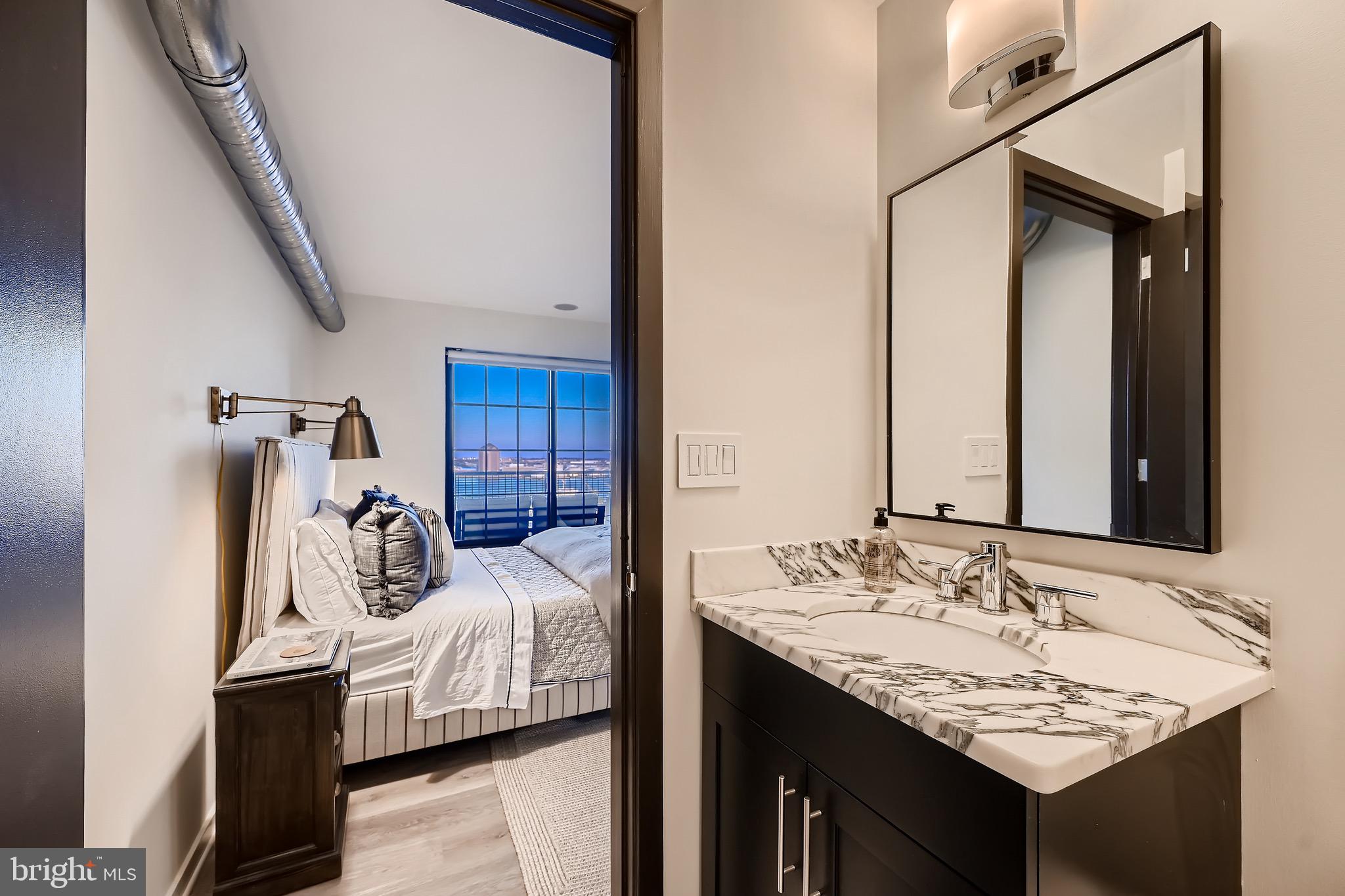 1200 Steuart Street, Unit 1611 Baltimore, MD 21230 - Photo 28 of 34 a en suite bathroom with a sink and a mirror