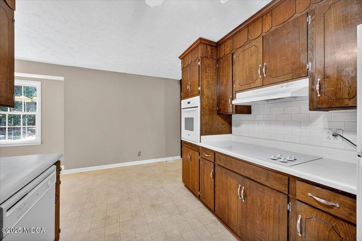 673 Commanche Drive Macon, GA 31210 - Photo 15 of 40 a kitchen with stainless steel appliances granite countertop a sink a stove and a refrigerator with wooden cabinets