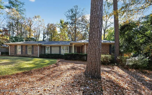 a view of a house with a large tree and a yard