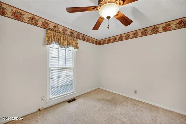 an empty room with chandelier fan