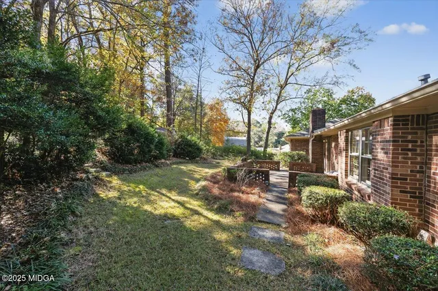 a view of backyard with swimming pool and green space
