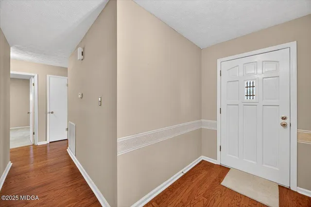 a view of a hallway with wooden floor and closet area