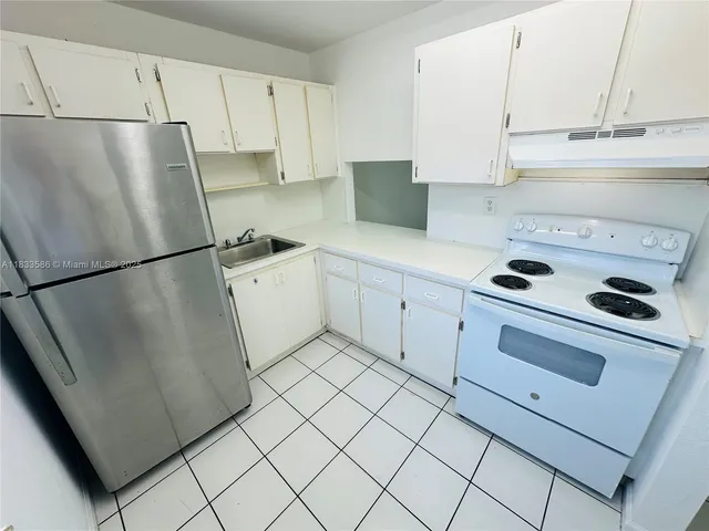 a kitchen with a refrigerator sink stove and cabinets