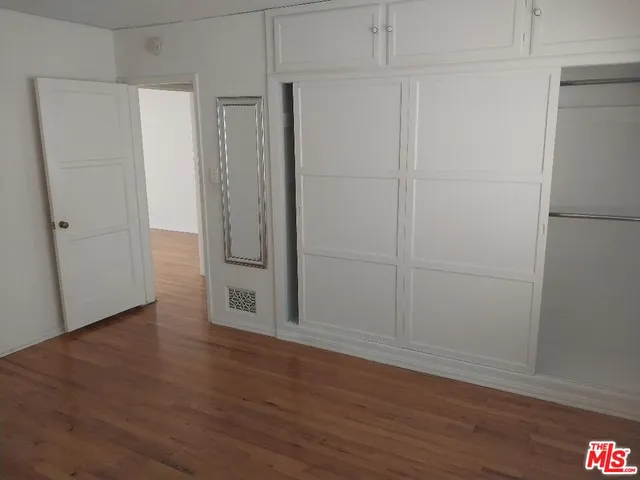 a view of wooden floor and closet in a room