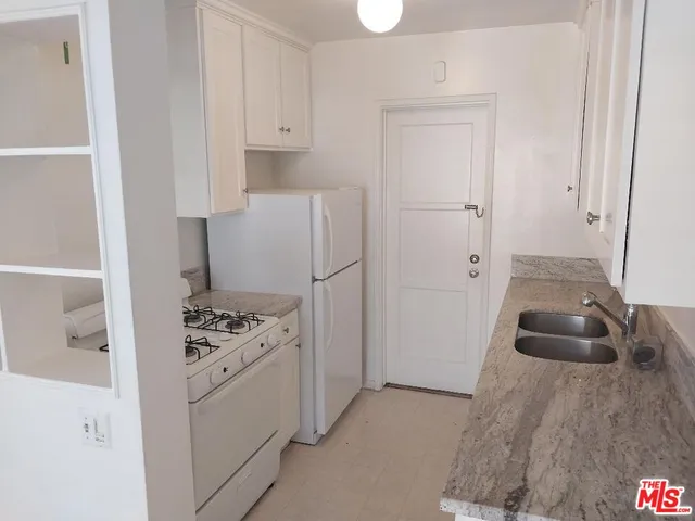 a kitchen with white cabinets and white appliances