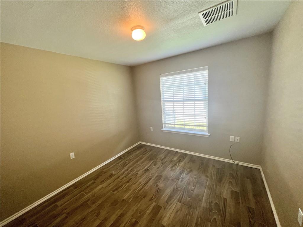 7813 Duber Lane Austin, TX 78747 - Photo 17 of 20 an empty room with wooden floor and windows