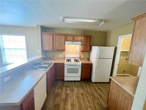 a kitchen with a stove a refrigerator and a sink